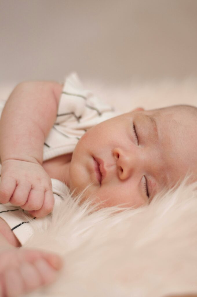 A peaceful baby sleeping soundly on a soft, plush blanket with eyes closed.